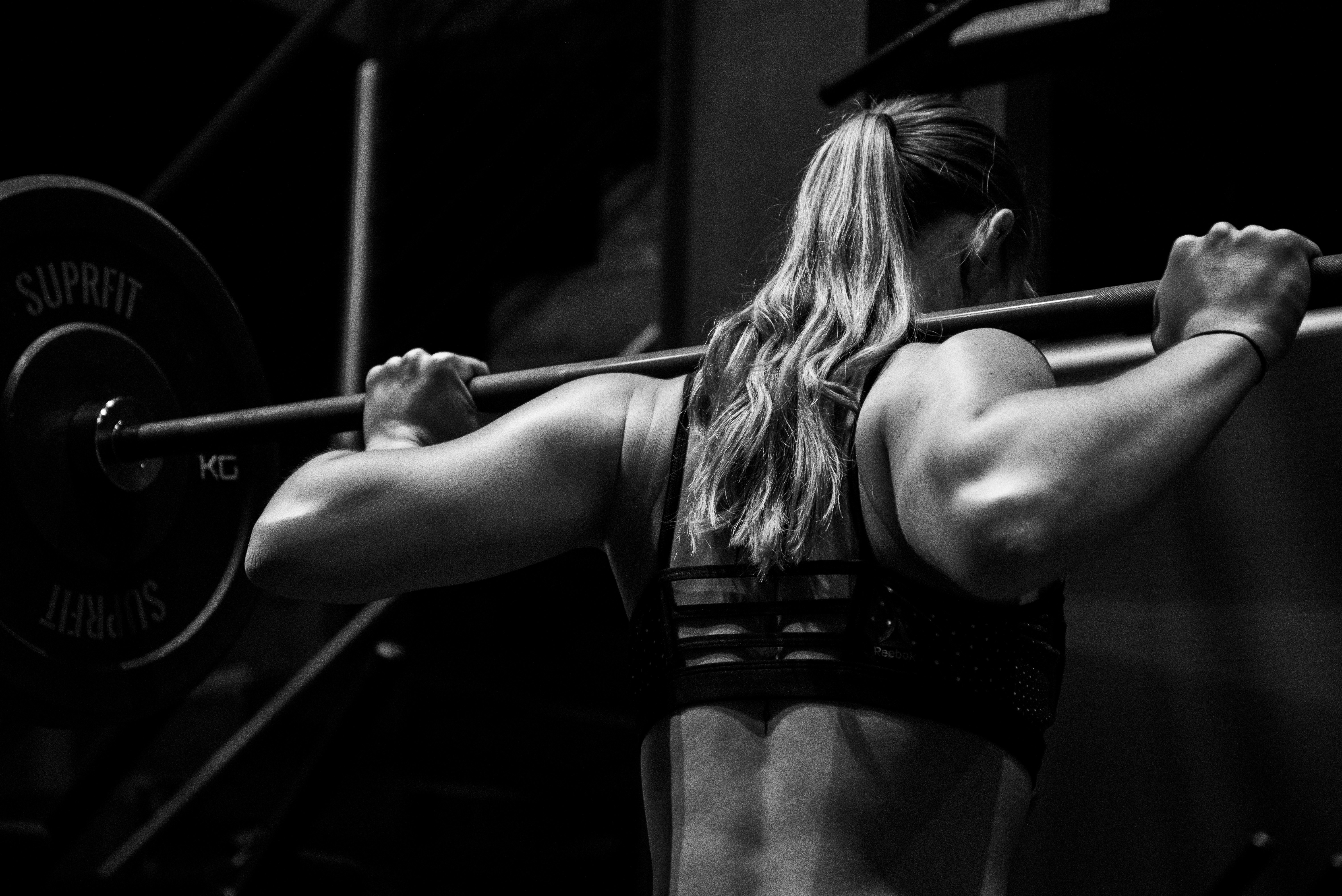 Female lifter performing a barbell squat — serious strength training
